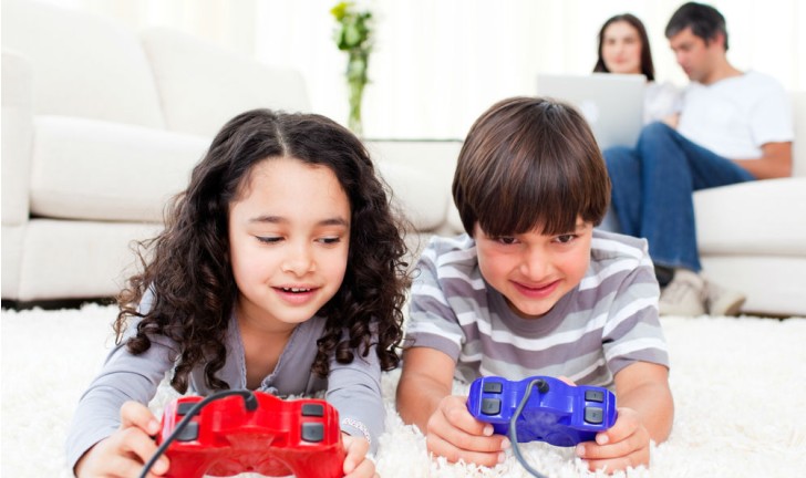 Um menino bonito de 4 anos joga um console de jogos segura um