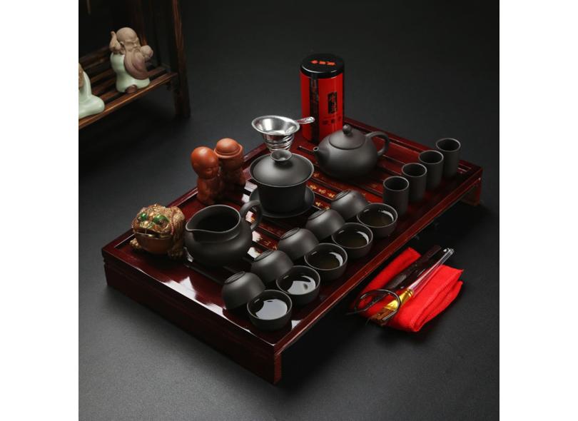Um jogo de chá com um bule e xícaras em uma placa de madeira