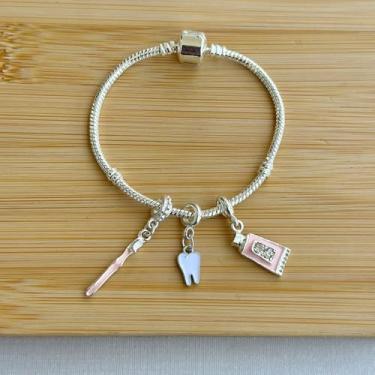 Imagem de Pulseira profissão com 3 berloques dente, escova de dentes e pasta de dentes - banhados a prata