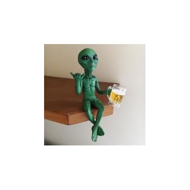 Imagem de 1 estatueta alienígena pendurada na prateleira com caneca de cerveja, decoração peculiar de canto sentado para estante, mesa, borda de mesa, exibição de festa, verde
