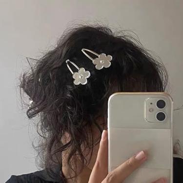 Imagem de Um grampo de cabelo de flor cuidadosamente projetado com um acessório de cabelo quebrado na parte de trás da cabeça
