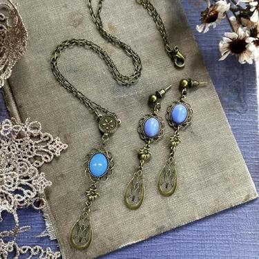 Imagem de 1 conjunto de brincos e colar femininos vazados em forma de gota com imitação de pedra da lua de vidro azul para festas e bailes.