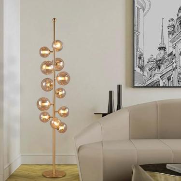 Imagem de Luminária de chão criativa com 12 globos de vidro, em tons âmbar e azul, estilo vertical, para decoração de interiores. Luminária alta em metal polido, ideal para sala de estar e quarto.