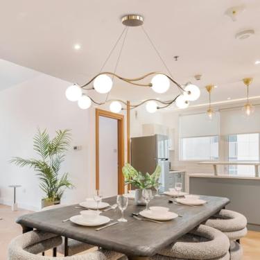 Imagem de Lustre Sputnik moderno dourado com 8 lâmpadas, altura ajustável, em metal dourado com cúpulas brancas, ideal para sala de estar, sala de jantar e lavabo.