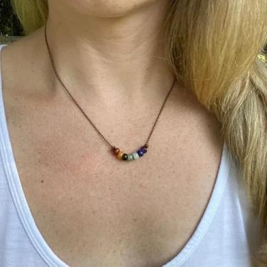 Imagem de 1 colar de estilo vintage com sete pedras naturais em um material de metal natural, em uma cor bronze antigo, adequado para roupas femininas de férias