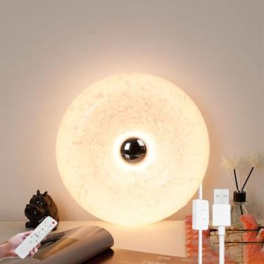 Imagem de Luminária de parede em formato de donut com LED laranja, controle remoto e interruptor no cabo. Possui porta USB para carregamento e função timer. Ideal para cabeceira, com intensidade de lu
