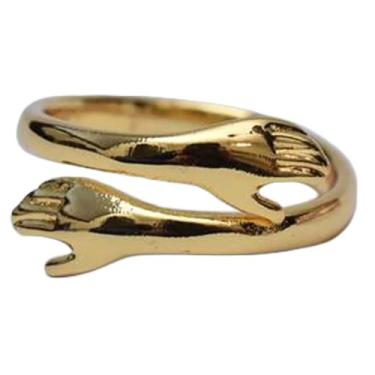 Imagem de 1 anel de liga única e minimalista dourado aberto nas costas com um design de abraço distintivo, perfeito para uso diário ou encontros
