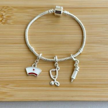 Imagem de Pulseira profissão com 3 berloques chapéu de enfermeira, estetoscópio e seringa - banhados a prata